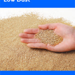 A hand holding a small pile of light tan granules over a larger spread of the same granular material, with blue banners reading 'Low Dust' and 'For a healthy home'.