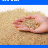 A hand holding a small pile of light tan granules over a larger spread of the same granular material, with blue banners reading 'Low Dust' and 'For a healthy home'.